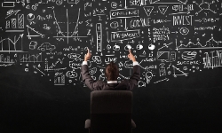 businessman-sitting-in-front-of-blackboard